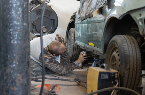 The mechanic repairs a car threshold.