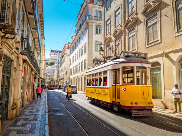 persone che camminano lungo la linea del tram nel centro di lisbona, portogallo - cable stayed foto e immagini stock