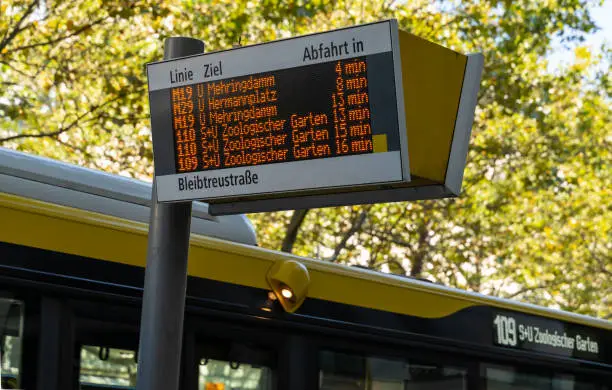 Germany, Berlin, September 10,2023 - Low angle view timetable at busstop against bus Berlin Charlottenburg Kurfürstendamm