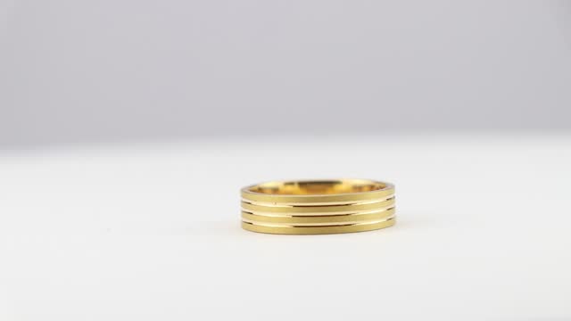 View of a golden ring rotating on a white background. Gold ring details by a rotational view