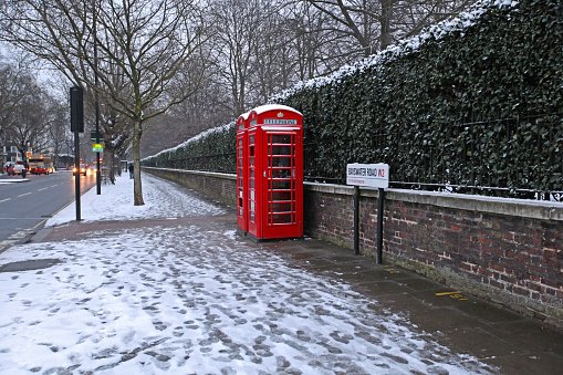 London, United Kingdom - January 18, 2013: Red Telephone Boxes at Bayswater Road Covered With Snow Cold Winter in Capital City.