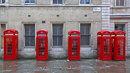 London, United Kingdom - January 19, 2013:  Five Red Telephone Booths at Broad Court Street in Capital City Winter Day.