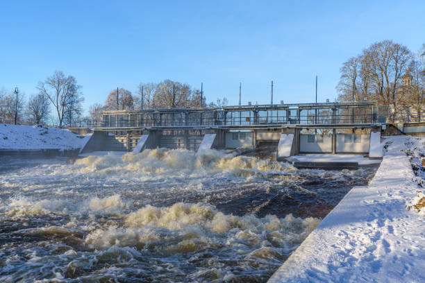 Water flushing from an open gate at a hydro electric power plant in Sweden, on a cold winter day with sunlight and misty water