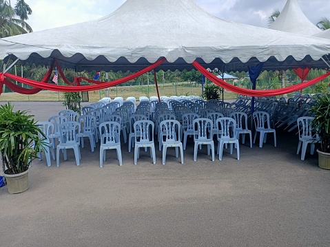 Rows of chairs and tables in a tent for an occasion. photo taken in malaysia