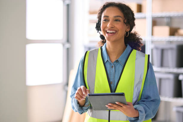 istock Woman Working In Warehouse Wearing Headset Using Digital Tablet 1682276598