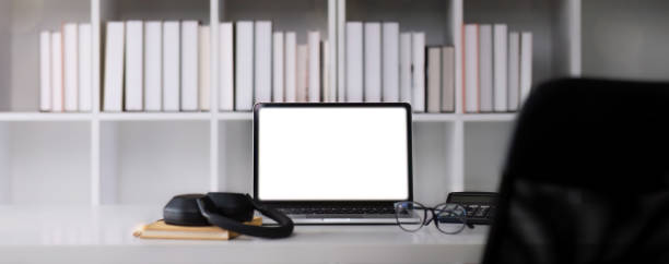 istock Front view of an open laptop computer with a blank white screen displayed on a work desk. 1682280935