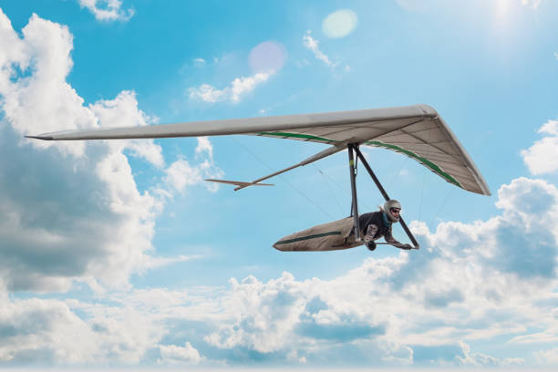 Hang glider pilot soar in the blue sky Hang glider pilot soar in the blue sky with clouds. Dream of flying come true. glider hang glider hanging sky stock pictures, royalty-free photos & images