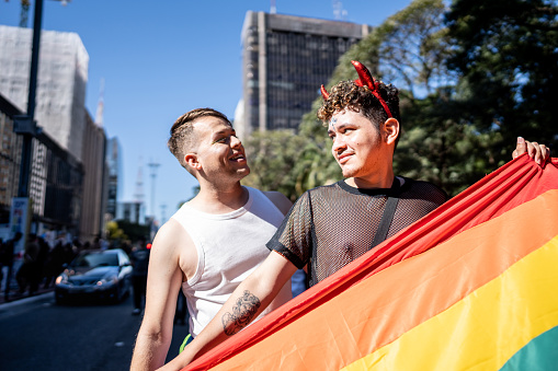 Gay couple holding a raindow flag at the Gay Parade