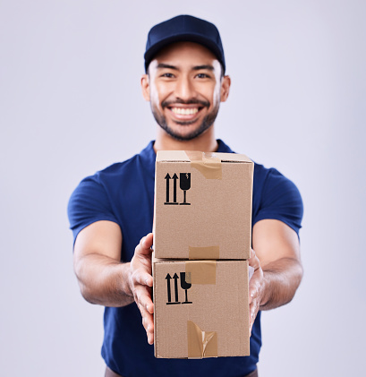 Smile, portrait and delivery guy with boxes in studio, safe transport for ecommerce supplier product. Package, logistics and happy courier mail man on white background for giving sales and services.
