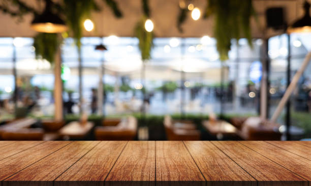 istock Empty wooden table top with lights bokeh on blur restaurant background. 1682297735