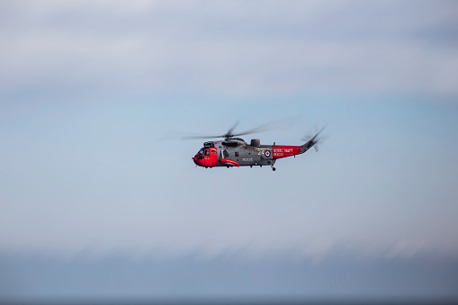 Royal Navy seeking search and rescue helicopter hovering above the sea in the north cost of England