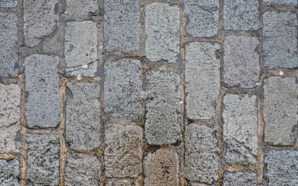 Wet rectangular cobble stone road, texture photographed from above stock photo