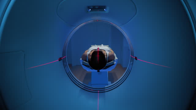 In the Medical Laboratory, Footage of an Anonymous Female Patient Lying on a CT or MRI Scan Bed Undergoes Scanning Procedure with Red Lasers. Bed Moves Towards Camera. Static Shot