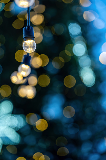 garland of light bulbs on defocused christmas lights background, shallow depth of field, copy space