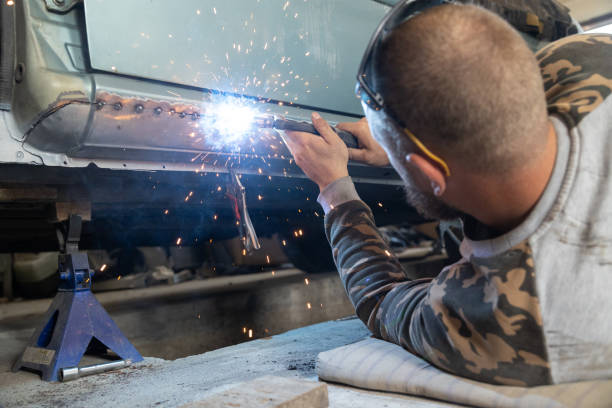 istock The mechanic welds a new threshold to a car. 1682367604