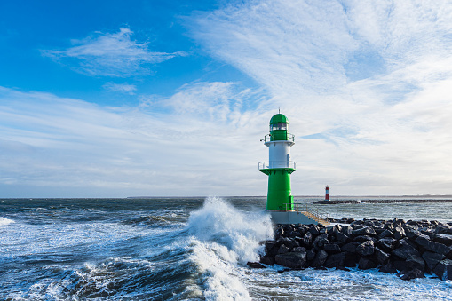 Pier and waves on shore of the Baltic Sea in Warnemuende, Germany