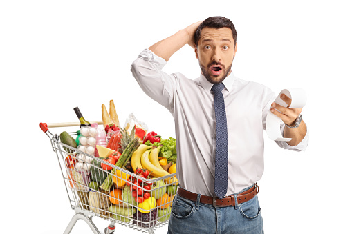 Man with a shopping cart holding a shockingly expensive bill isolated on white background