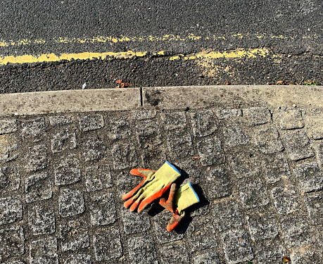 Work gloves discarded on a pavement