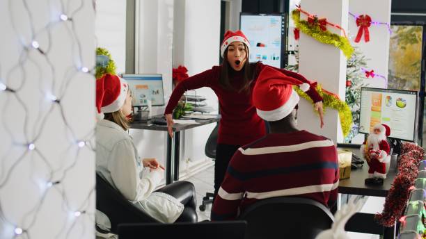 istock Workers play pantomime in xmas office 1682443398