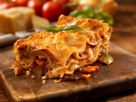 Baking dish with tasty vegetable lasagna on wooden background. Healthy food. Photo for the menu.