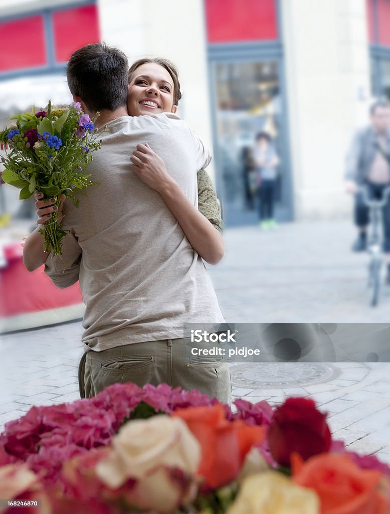 S'enlacer jeune couple dans un marché aux fleurs - Photo de 20-24 ans libre de droits