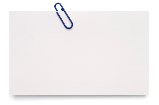 A blank index card with a paper clip, isolated on white.