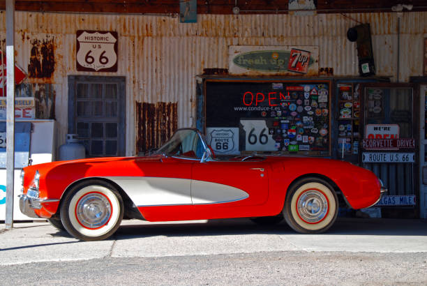 Beatty, NV, USA - A long abandoned vehicle has desert vegetation growing around the metal remains on a hot summer day.