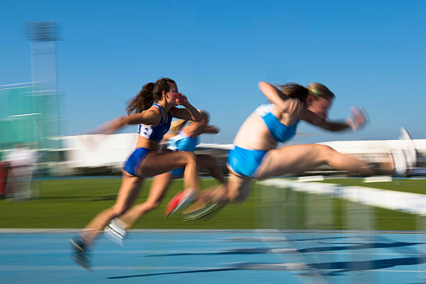 молодые женщины на препятствия в беге на 100 м - hurdle sports track track and field playing field стоковые фото и изображения