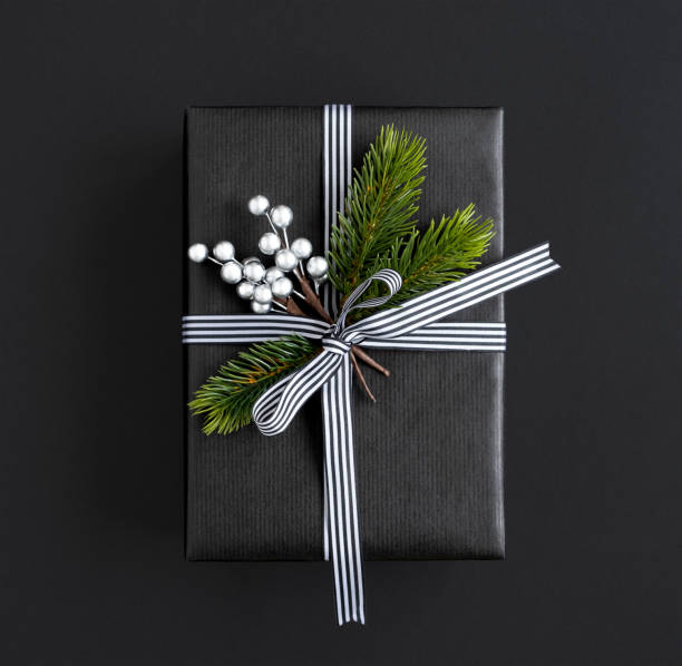 istock Black gift box with ribbon, spruce branches and silver berries 1682482613