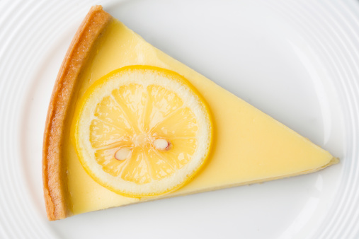 Lemon tartlets with meringue on a light background. With copy space.