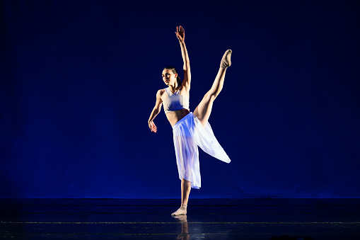 Teenage girl dancing contemporary dance on stage