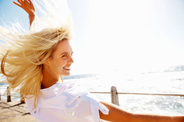 istock Beautiful woman enjoying breeze on a pier 168250034