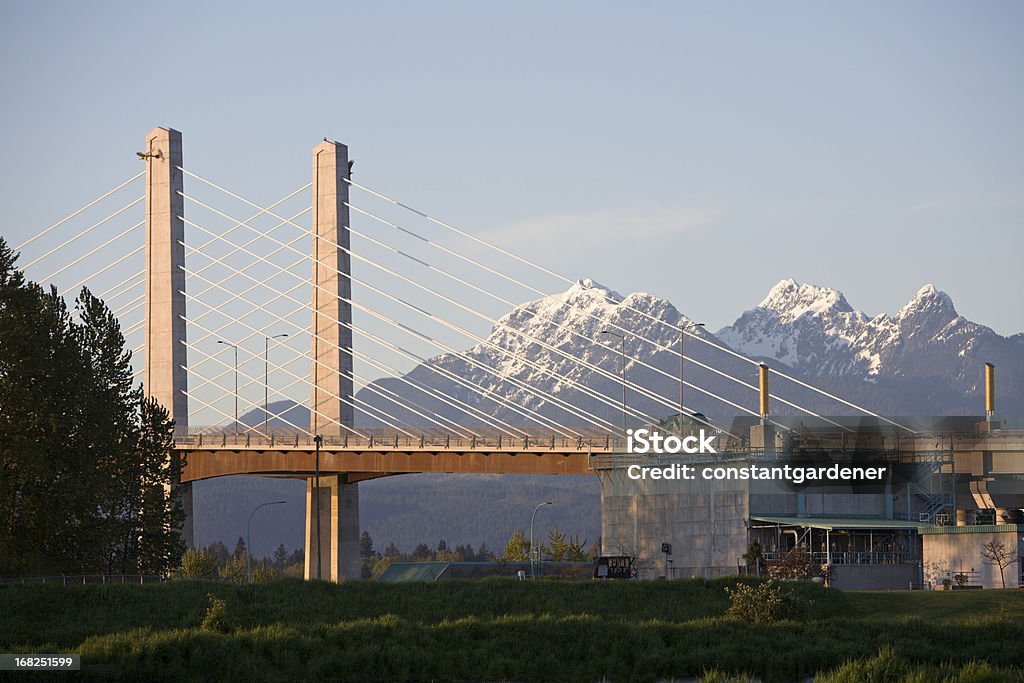 New Golden Ears Bridge With Snowcapped Mountains Evening shot of bridge with Golden Ears Mountain Peaks and Provincial Park in background. The Golden Ears Bridge is a new toll bridge that links Pitt Meadows And Maple Ridge British Columbia to Langley,Surrey and beyond.  There is an electronic tolling system that allows drivers to pay without stopping. The bridge crosses the Fraser River. *Golden Ears is one of the largest Provencial Parks in British Columbia  Langley - British Columbia Stock Photo