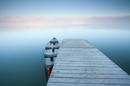 Canoe at rest on a calm foggy day at Riding Mountain National Park, Manitoba.