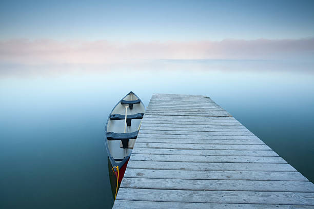 Riding Mountain National Park, Manitoba. Canoe at rest on a calm foggy day at Riding Mountain National Park, Manitoba. riding mountain national park stock pictures, royalty-free photos & images