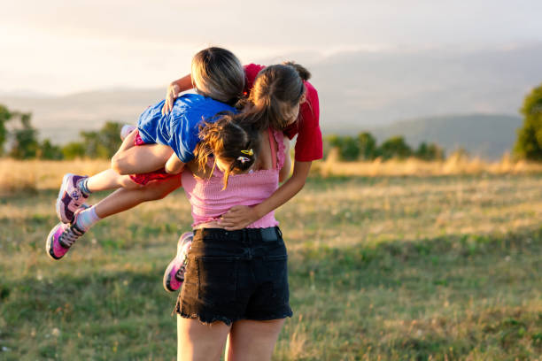 istock Mother carrying her two daughters on the hill at summer 1682519997