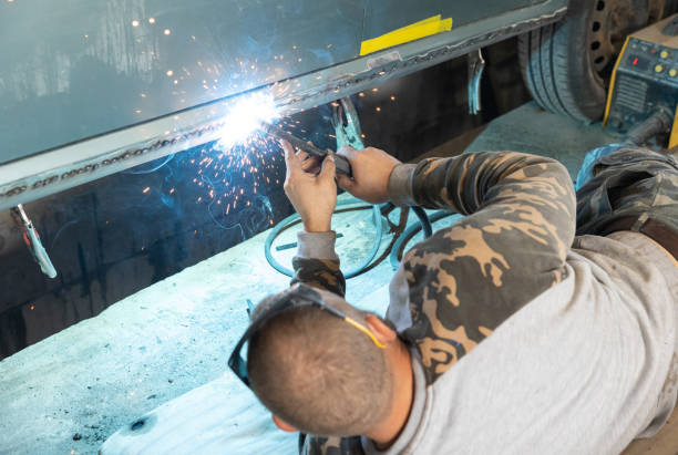 the mechanic welds a new threshold to a car. - car bodywork flash imagens e fotografias de stock