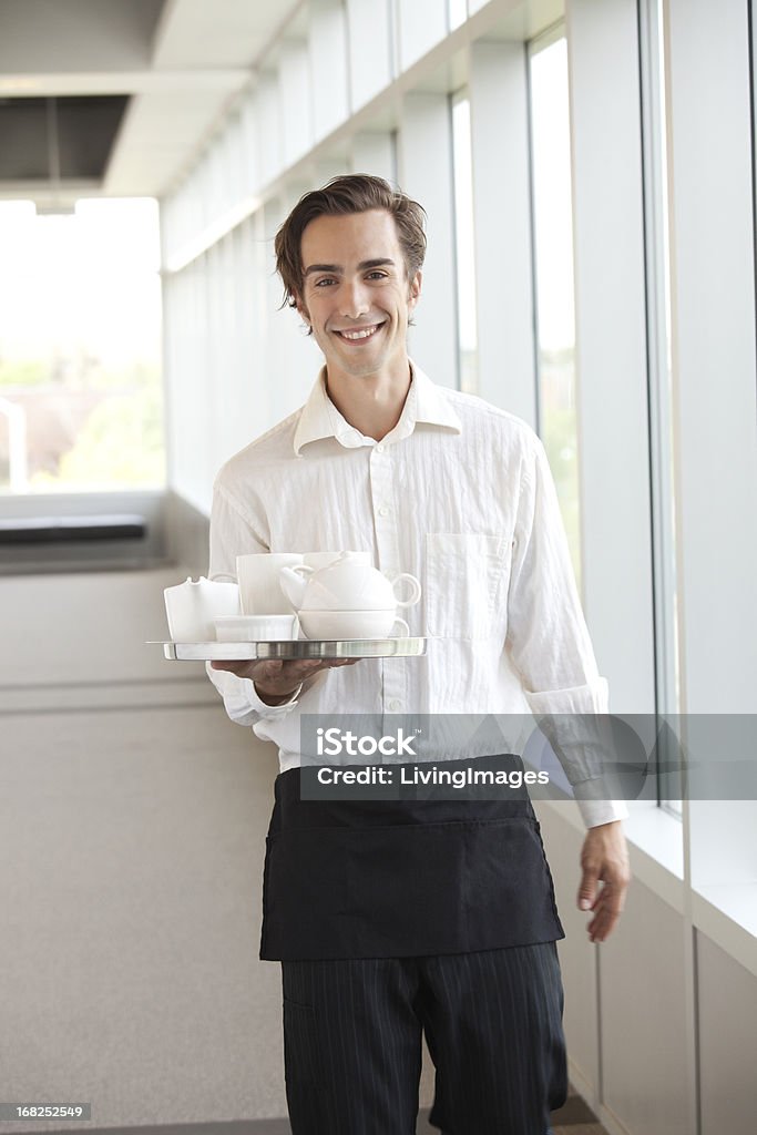Waiter Young man serving tea or coffee. Men Stock Photo