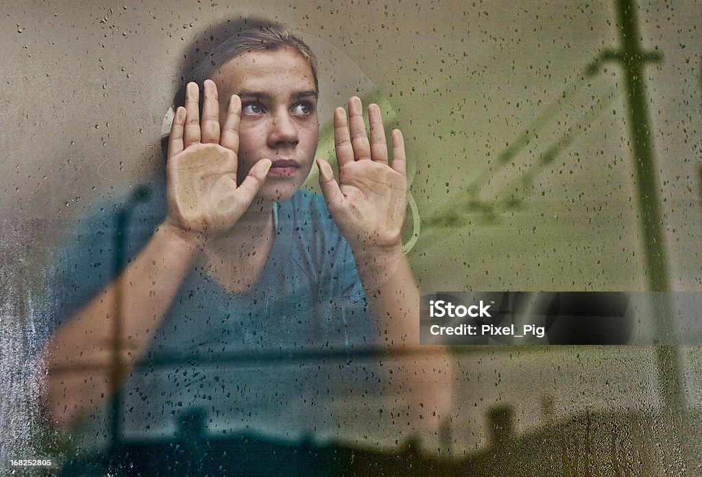 Dziewczyna wygląda przez okno sprawiając (z odbicia miasto - Zbiór zdjęć royalty-free (Okno)