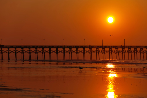 Sunrise behind the fishing pier in Surf City on Topsail Island in North Carolina.