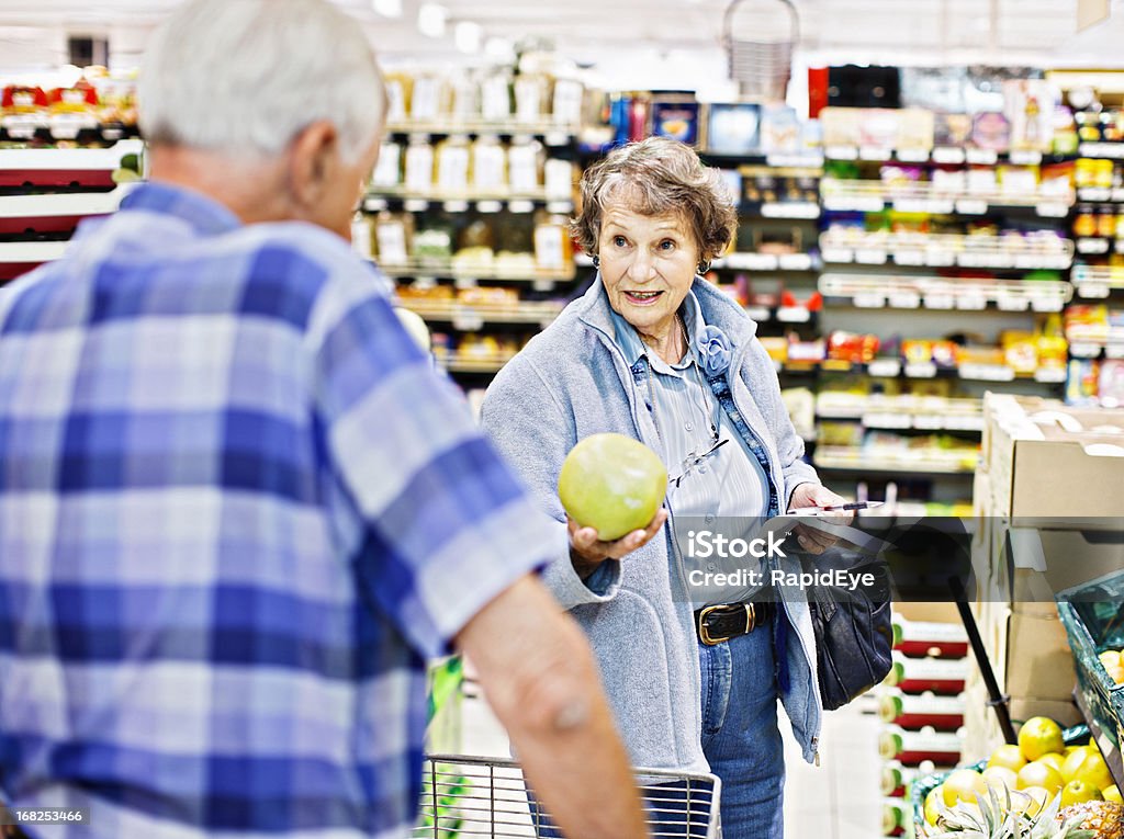 Senior donna marito ha consultato sul pompelmo acquisto in Supermercato - Foto stock royalty-free di Supermercato