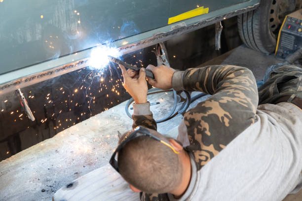 the mechanic welds a new threshold to a car. - car bodywork flash imagens e fotografias de stock