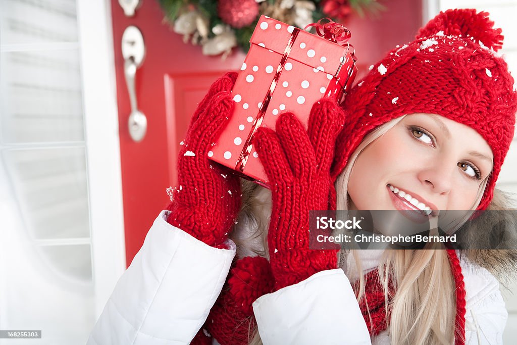 Christmas-Smiling woman holding present outside Smiling woman holding present sitting outside 20-24 Years Stock Photo