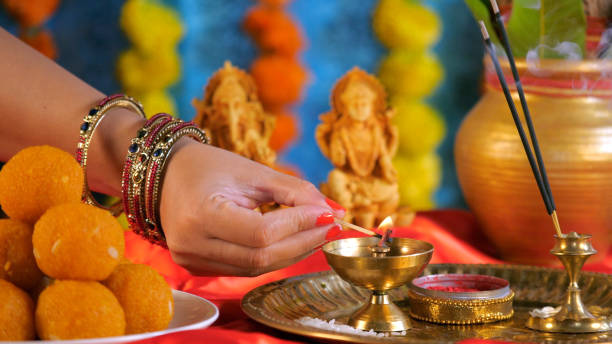 istock Female hands lighting a brass Diya kept on a Pooja Thali on Ganesh Chaturthi 1682554060