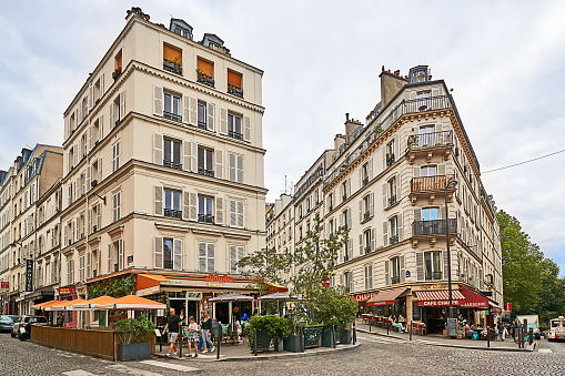 Paris, France - July 13, 2023: Pedestrians between the cafes on rue Tardieu in Paris.