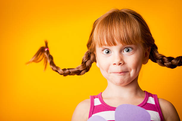 niña de pelo roja con mallas ascendente y cara más desenfadado - child surprise little girls human face fotografías e imágenes de stock