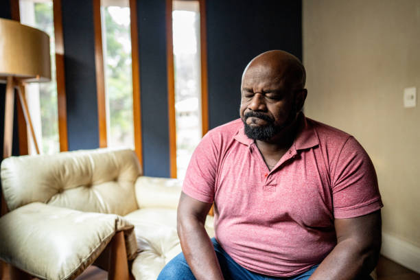 sad mature man at home - plussize model fotos stockfoto's en -beelden