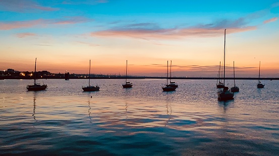 Witness the breathtaking beauty of a serene sunset at Dun Laoghaire Pier, where the tranquil waters of the sea meet the shimmering horizon. In this picturesque moment, boats gently sway on the calm waves, bathed in the warm, golden hues of the setting sun. Join us for a mesmerizing journey as we capture the magic of nature's canvas in one of Ireland's most scenic spots.