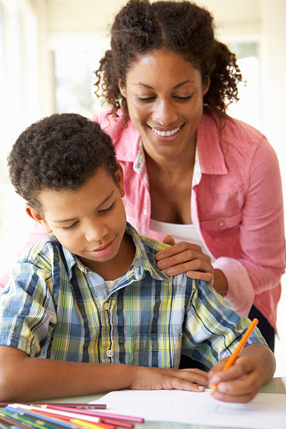 istock Smiling mother helping her son with his homework 168258086