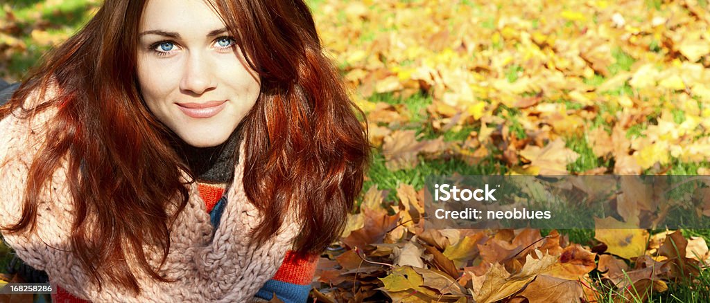 Kobieta z czerwone włosy leżący na jesień liście. - Zbiór zdjęć royalty-free (Jesień)